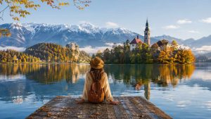 Une femme qui apprend à voyager hors saison au bord d'un lac enneigé.
